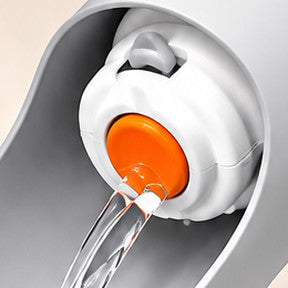 Close-up of the orange release button with water running from the cap
